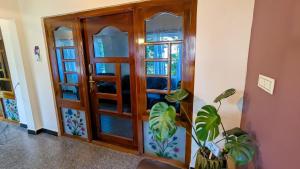 a room with a wooden door and a plant at Cloud Crest Homestay in Ooty