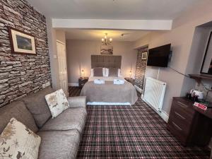 a bedroom with a bed and a stone wall at The Westbourne Guest House in Llandudno