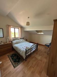 a bedroom with a bed and a large window at Le Chene Vert in Millac