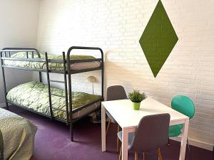 a room with a table and bunk beds and a table and chairs at Oasen Samsø in Nordby +115 photos
