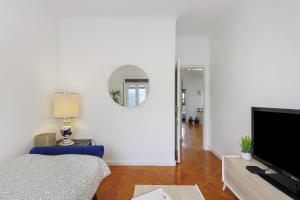 a living room with a couch and a tv at Azuaga House Sunny Charming Apt in Vila Nova de Gaia
