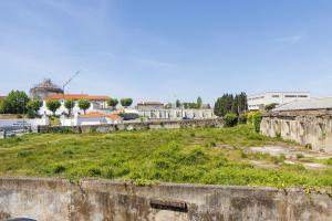 an old stone wall with a field of grass at Azuaga House Sunny Charming Apt in Vila Nova de Gaia
