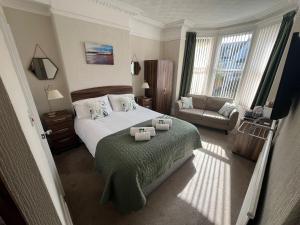 a bedroom with a bed with two towels on it at The Westbourne Guest House in Llandudno