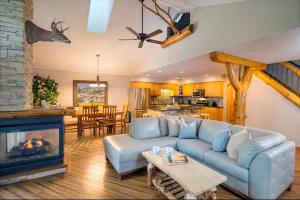 a living room with a blue couch and a fireplace at Natura Treescape Resort in Wisconsin Dells
