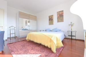 a bedroom with a large bed with a yellow blanket at Queen Home Paola in Favaro Veneto