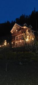 a house lit up at night with lights at Sukun Hostel in Sainj