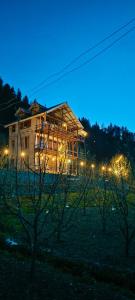 a house lit up at night with lights at Sukun Hostel in Sainj