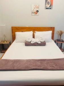 a bed with two pairs of shoes sitting on it at Sofia's Unit - 2 Bedroom with complimentary breakfast in Baguio