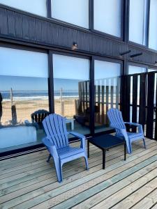 two chairs and a table on a deck with the beach at Rompe Olas in Maitencillo