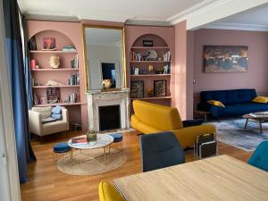 a living room with colorful furniture and a fireplace at Le Petit Jard'Inn in Chalons en Champagne