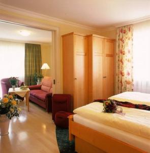 ein Hotelzimmer mit 2 Betten und einem Sofa in der Unterkunft Appartementhaus St. Florian in Bad Füssing