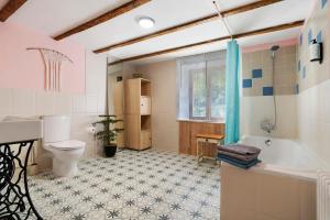 a bathroom with a tub and a toilet and a sink at Les Orchidées - Chambre in Savignac-de-Miremont