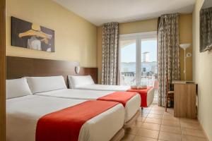 a hotel room with two beds and a window at Hotel Canal Olímpic in Castelldefels +38 photos