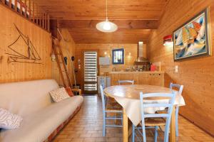 a kitchen and dining room with a table and chairs at Petite Villa Mitoyenne Dans Pinède in Lacanau-Océan