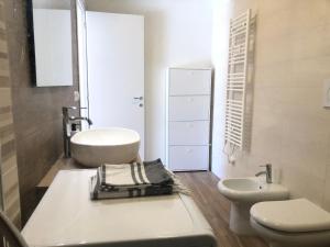 a white bathroom with a sink and a toilet at La Tana de Il Lupo e La Volpe in Centobuchi