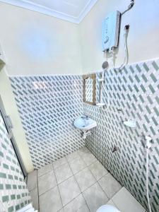 a bathroom with a sink and a tv on the wall at Cajanus Inn & Safaris in Karatu +10 photos