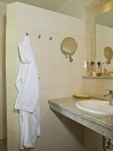 a bathroom with a sink and a towel hanging on the wall at Appartementhaus St. Florian in Bad Füssing