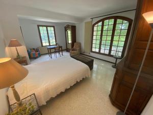 a bedroom with a large bed and a living room at Villa les Jules in Thoard +30 photos