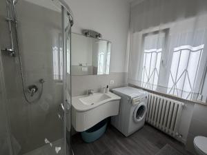 a bathroom with a sink and a washing machine at Appartamenti Federica 12T in Milano Marittima +21 photos