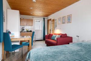 a bedroom with a bed and a desk and a kitchen at Haus Sonneneck in Oesterdeichstrich