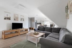 a living room with a couch and a tv at Haus Sonneneck in Oesterdeichstrich