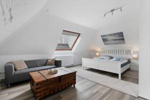 a living room with a couch and a bed at Haus Sonneneck in Oesterdeichstrich