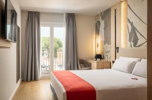 a hotel room with a bed and a balcony at Hotel Canal Olímpic in Castelldefels