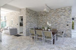 a dining room with a brick wall and a table and chairs at Appartamenti Federica in Milano Marittima