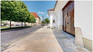 a cobblestone street next to a white building at Main Square Olive Studio in Trnava