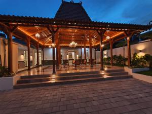 a pavilion with tables and chairs on a patio at Dalem Kamulyan Kraton in Timuran