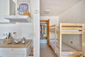 a small room with a bunk bed and a kitchen at Monolocale al centro della Costa Smeralda in Cugnana Verde