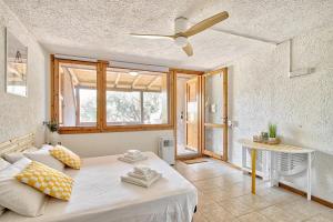 a bedroom with a bed and a ceiling fan at Monolocale al centro della Costa Smeralda in Cugnana Verde