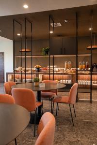a restaurant with tables and chairs and a counter at LVG Hotel Collection - Belfiore in Mantova
