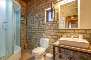 a stone bathroom with a sink and a toilet at Polilimnio Foteini's Mini Castle in Metamórfosis +26 photos