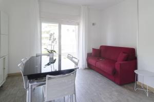 a living room with a red couch and a table at Appartamenti Federica 12P in Milano Marittima