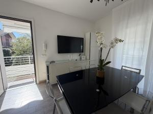 a living room with a black table and a tv at Appartamenti Federica 12P in Milano Marittima