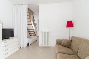 a living room with a couch and a staircase at Appartamenti Federica 5 in Milano Marittima