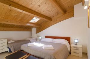 two beds in a room with wooden ceilings at Appartamenti Federica 5 in Milano Marittima