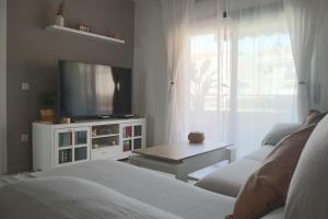 ein Schlafzimmer mit Bett, Fernseher und Tisch in der Unterkunft Darahome in Cunit