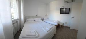 a bedroom with two beds and a tv on the wall at Appartamenti Federica 12P in Milano Marittima