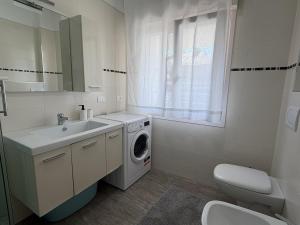 a bathroom with a washing machine and a sink at Appartamenti Federica 12P in Milano Marittima +20 photos