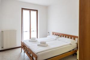 a bedroom with a bed with white sheets and a window at Residence Primera Rompala, GTSGroup in Tignale +39 photos