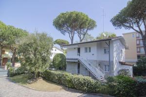 a white house with a staircase in a street at Appartamenti Federica 12P in Milano Marittima