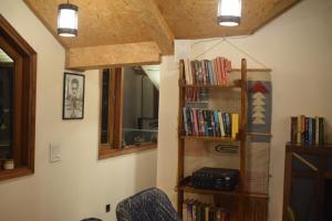 a room with a book shelf with books at Roots & Rustle homestay in Kūfrī +10 photos