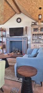 a living room with a blue couch and a fireplace at Roots & Rustle homestay in Kūfrī