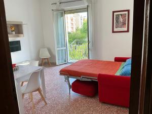 a bedroom with a red bed and a table and a window at A due passi dal mare in Praia a Mare