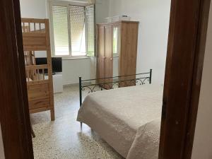 a bedroom with a bed and a chair and a window at A due passi dal mare in Praia a Mare
