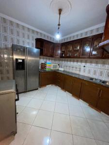 a kitchen with wooden cabinets and a stainless steel refrigerator at Central Private Haven in Martil