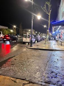 a cobblestone street at night with cars parked at Central Private Haven in Martil