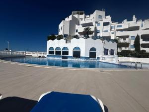 a swimming pool in front of a white building at Perlazul in Peniscola